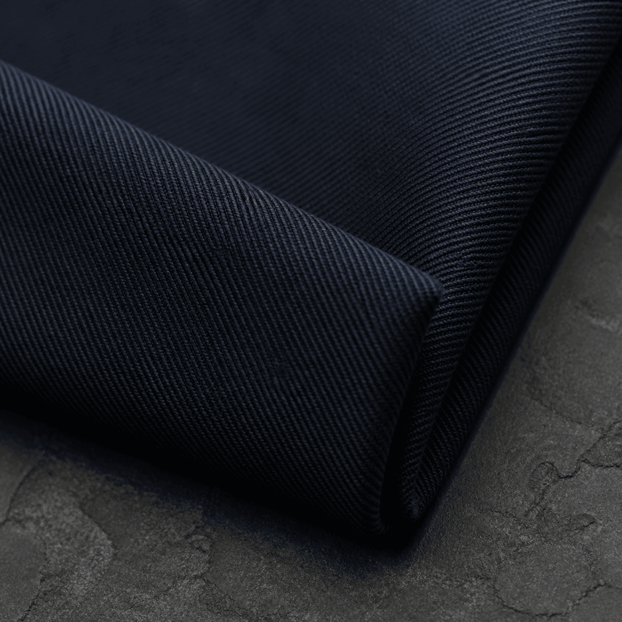 Macro view of dense ink cotton twill with a visible diagonal weave